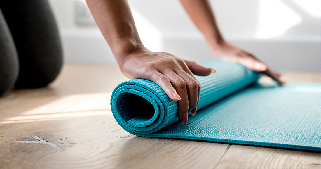 woman rolling up teal exercise mat
