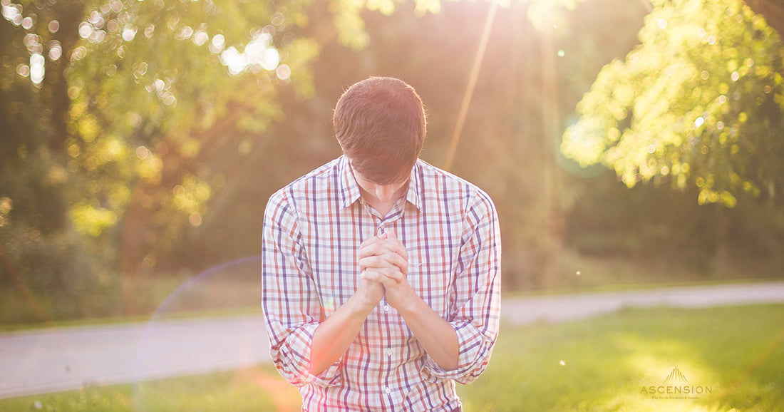 man kneeling in prayer outside
