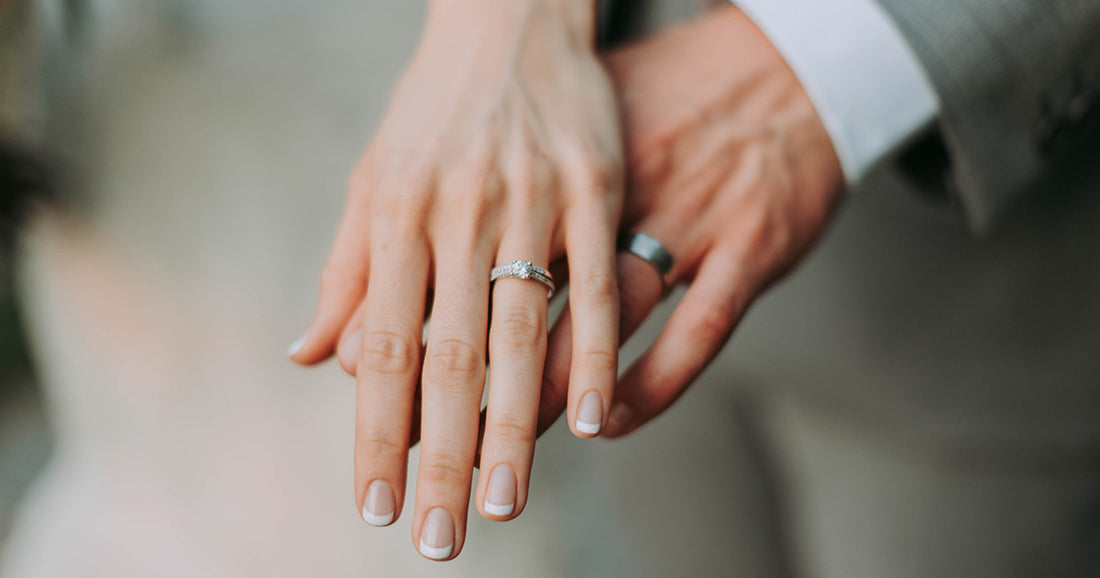 couple wearing marriage rings hold hands