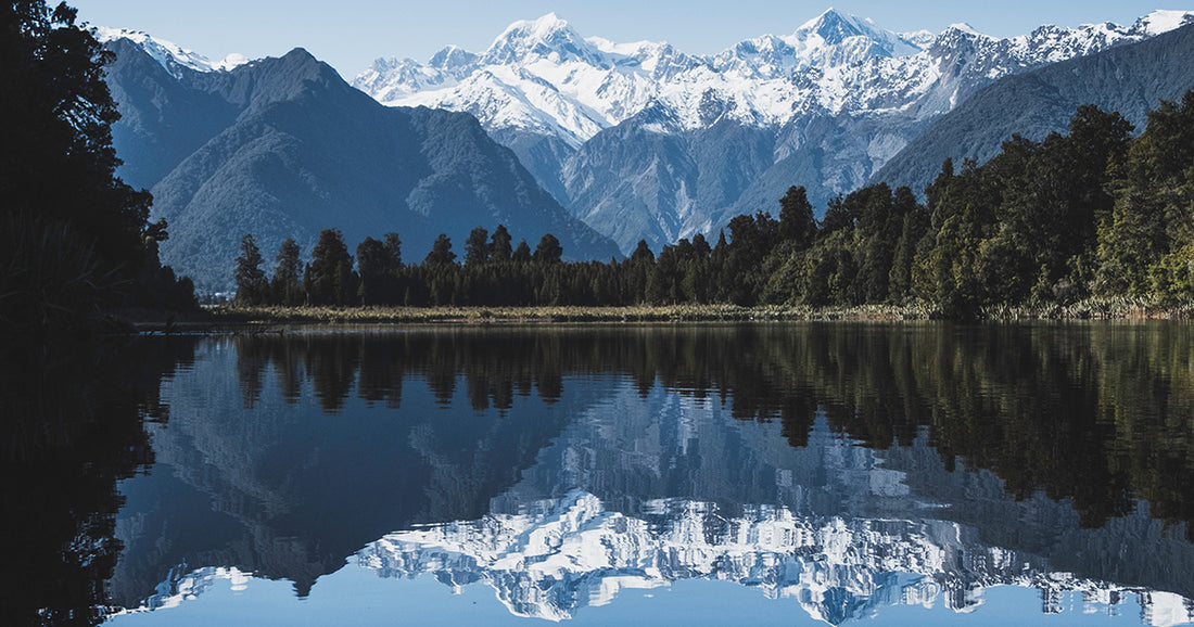 peaceful scene of mountains reflected on a still lake