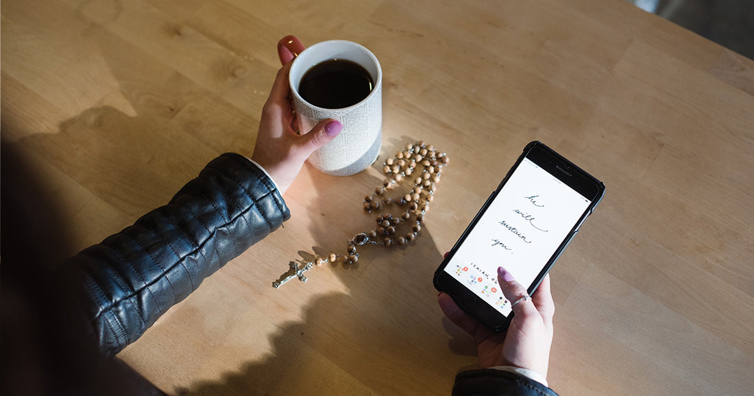 woman on phone holding coffee and a rosary