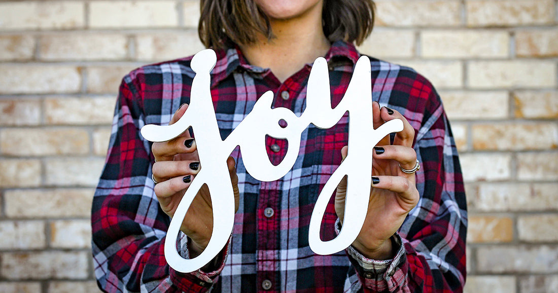 woman holding a sign that says Joy