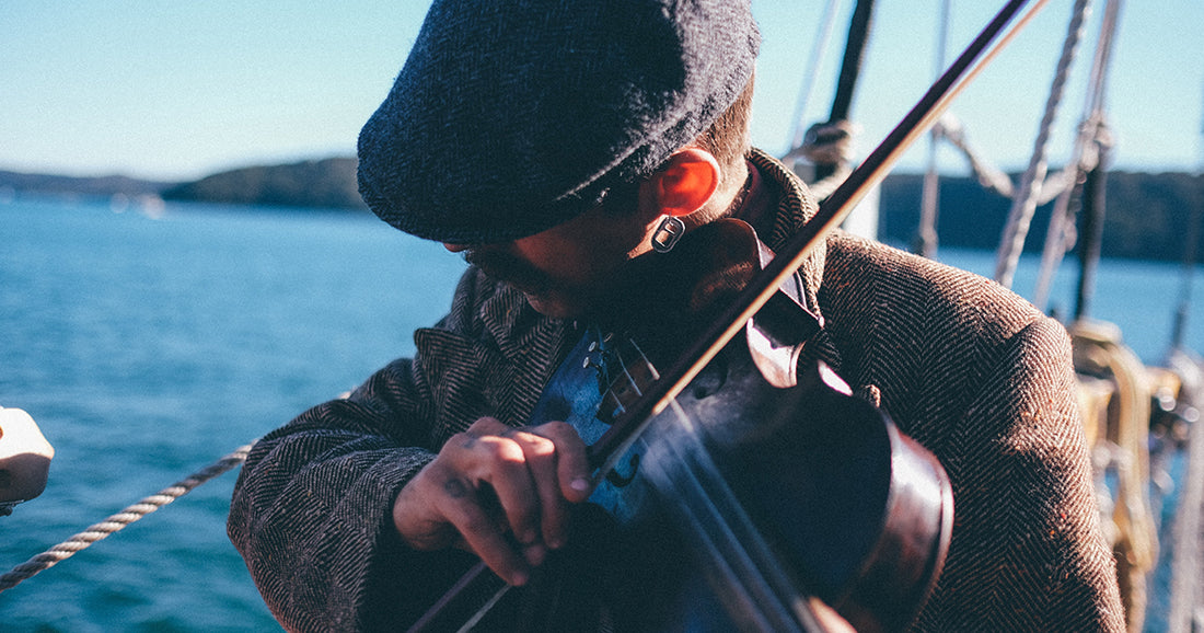 man in hat plays a fiddle or violin