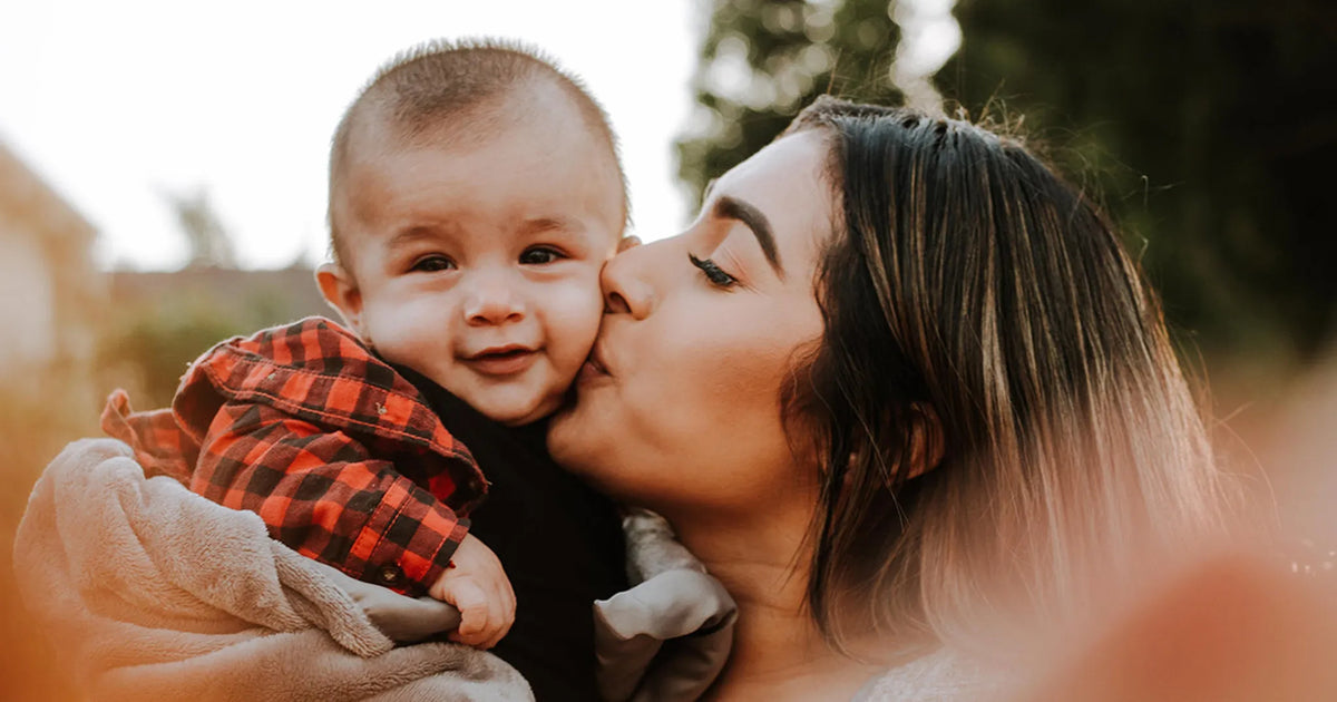 mother kisses her child on cheek