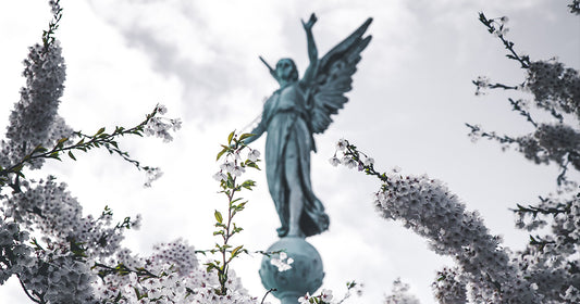 guardian angel statue surrounded by flowers