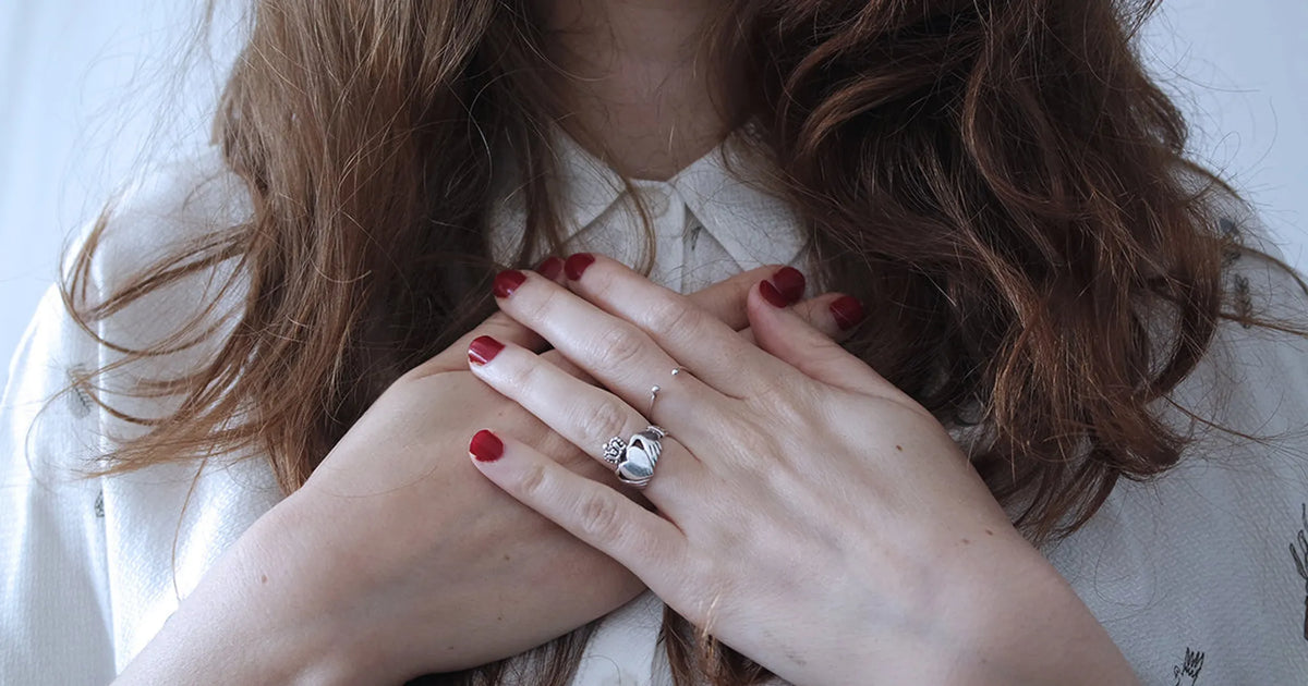 woman with hands crossed over chest wearing ring