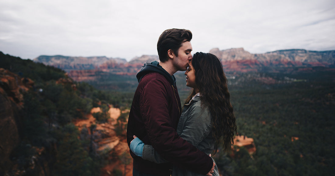 man kissing a woman's forehead