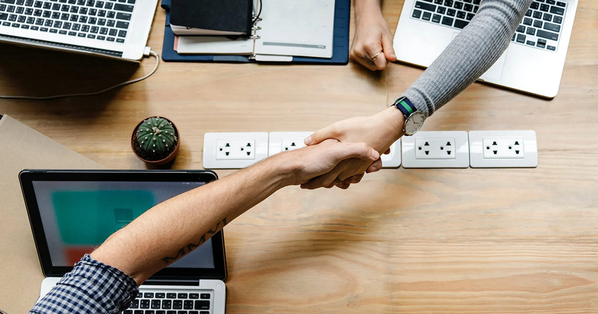 man and woman shake hands at a meeting