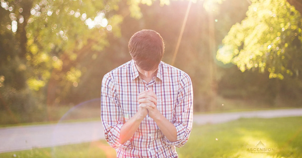 man kneeling in prayer outside