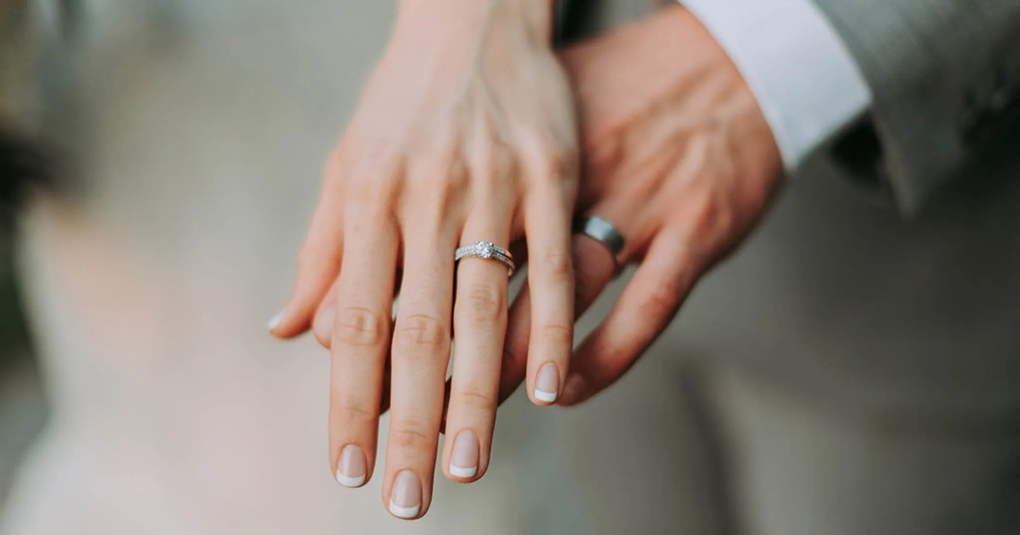 couple wearing marriage rings hold hands