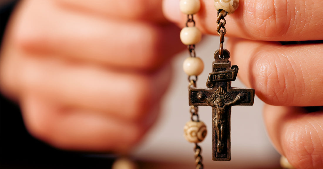 person praying with a rosary