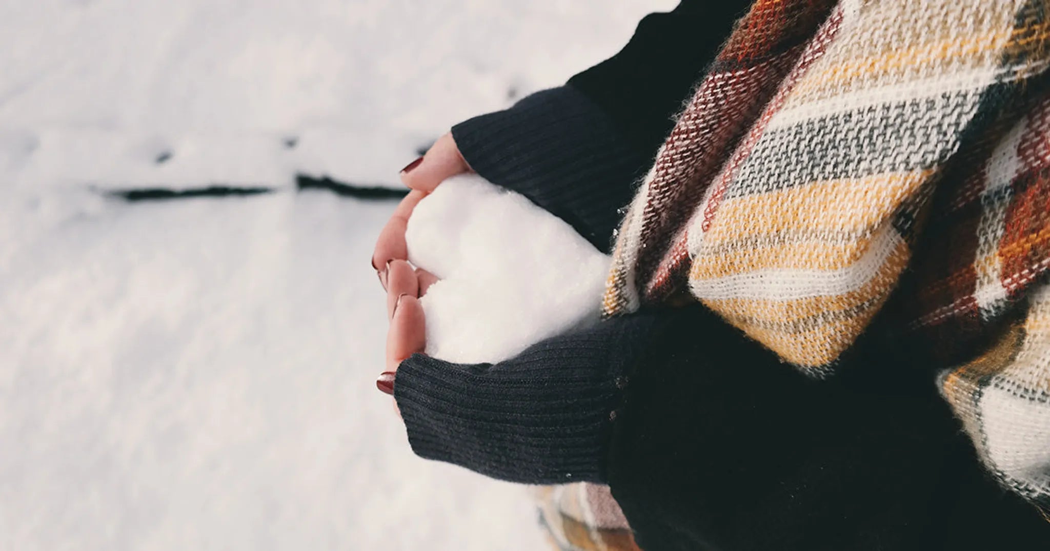 girl holding snow in the shape of a heart