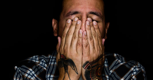 stressed out man covers his face with hands