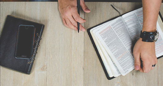 table with a bible, journal, and phone