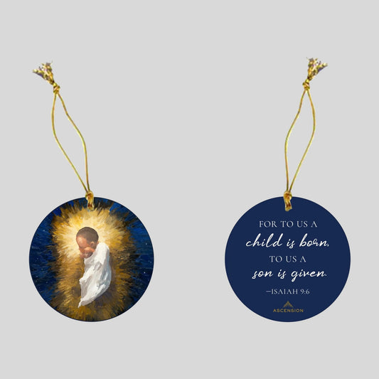 Decorative Christmas ornament with a scene of the baby Jesus in the manger on one side, and biblical text on a blue background on the other side.