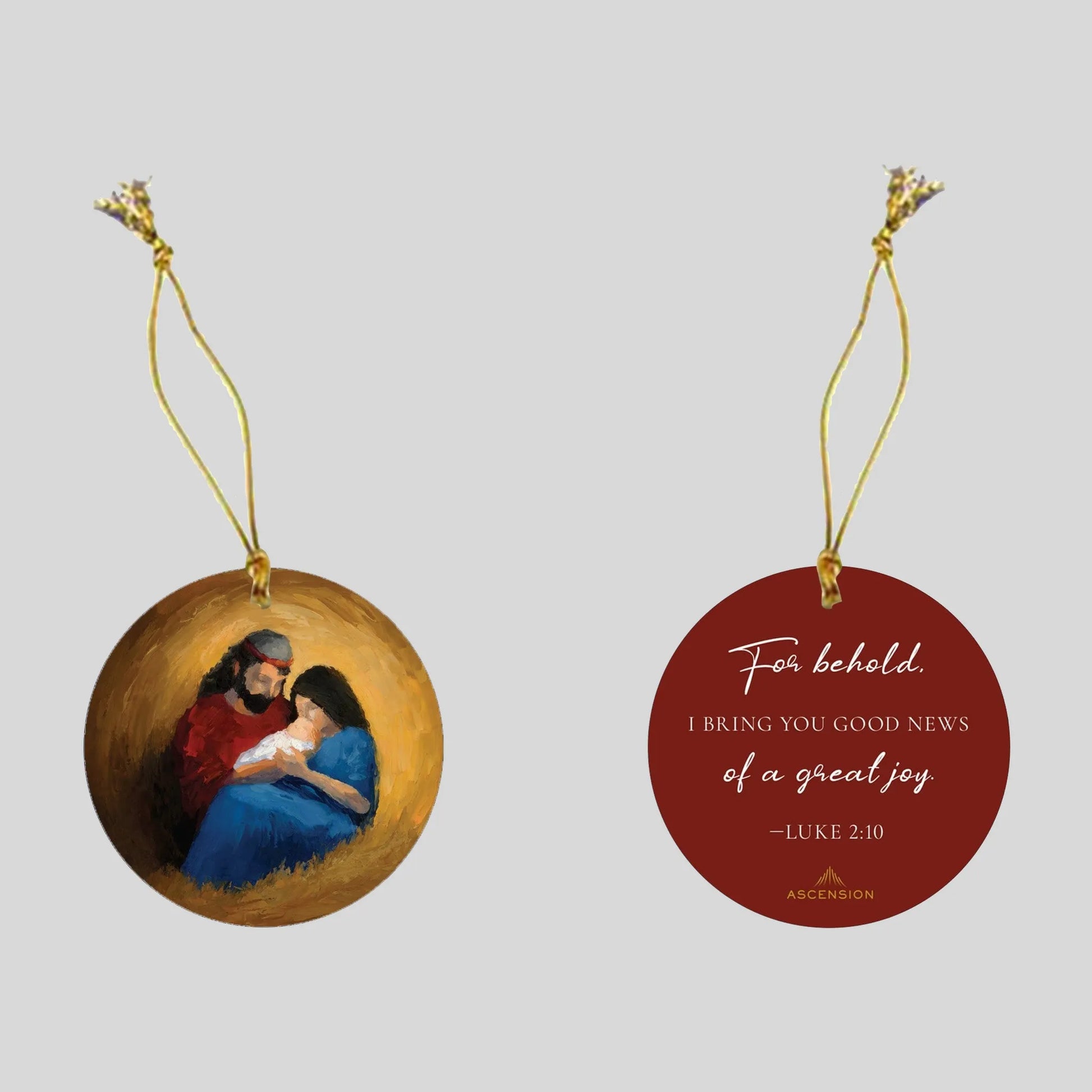 Decorative Christmas ornament with a scene of the nativity on one side, and biblical text on a red background on the other side.