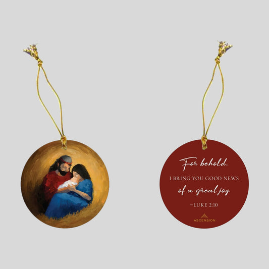 Decorative Christmas ornament with a scene of the nativity on one side, and biblical text on a red background on the other side.