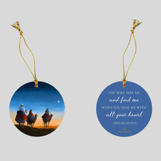 Decorative Christmas ornament with a scene of the three wise men on one side, and biblical text on a blue background on the other side.